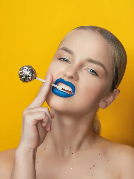 Model Nosi Niebieskie Szminka Pozowanie Brokatem Lizak Żółtym Tle — Zdjęcie stockowe