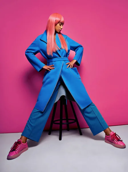ピンク髪ピンクの背景でポーズ ブルーのスーツを着てモデル — ストック写真