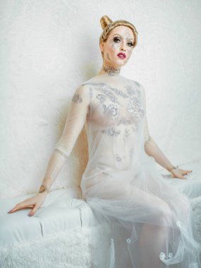 Beyaz arka plan üzerinde elbise şeffaf poz yaratıcı makyaj ile model