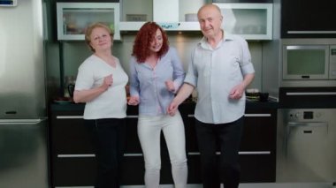 Büyük aileler ve kızları mutfakta dans ediyorlar.