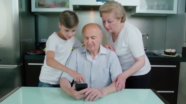 Neto Ensinando Avós Usando Smartphone — Vídeo de Stock