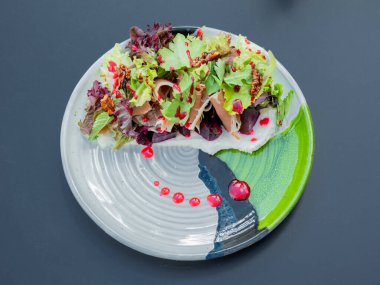 Tabakta salata, ahşap masada.