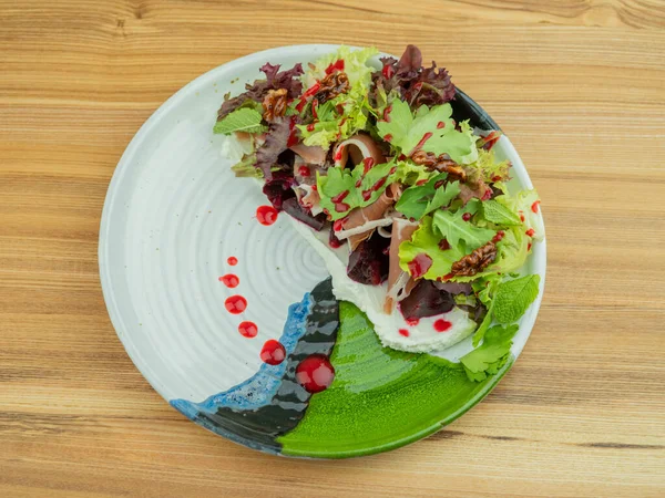 Tabakta salata, ahşap masada.