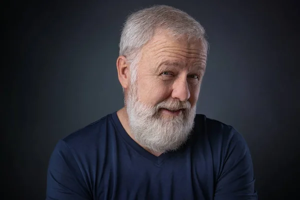 Portrait of senior with gray beard and a suspicious look