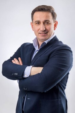 Mavi takım elbiseli ve gülümseyen orta yaşlı yakışıklı bir CEO portresi.