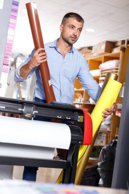 Erkek yazdırma işçi ile renkli kağıt rulo
