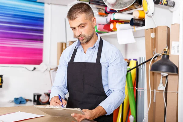 portrait of a working man at printer studio