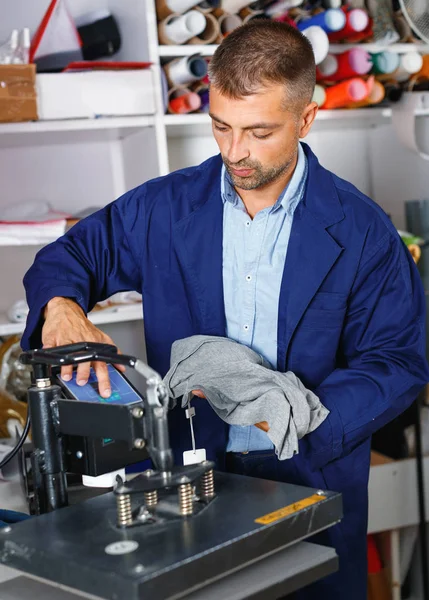 Manliga arbetaren gör tryck på skjorta — Stockfoto
