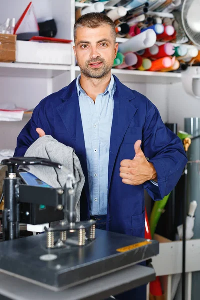 Manliga arbetaren gör tryck på skjorta — Stockfoto