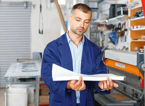 Yrke, jobb, människor, Workman i speciella kläder med papper — Stockfoto