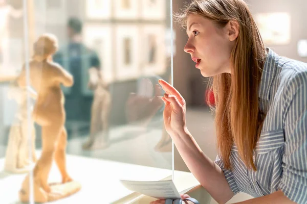 Jong mooi meisje beschouwt exposities in Museum. — Stockfoto