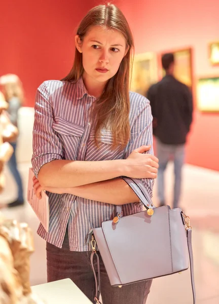 Portret van jonge vrouw met gids kijkend naar Foto's in Museum of Arts — Stockfoto