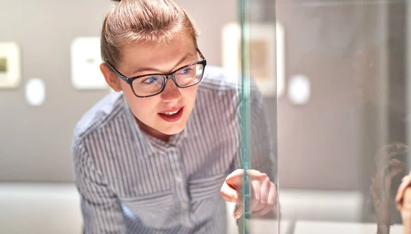 Vrouw bezoeker in historisch museum kijken naar kunstobject — Stockfoto