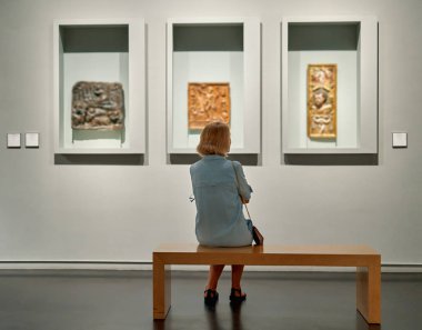 Müzede sanat eseri arayan ziyaretçi