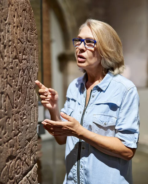 Mulher estudando hieróglifos de escrita antiga no museu de artes — Fotografia de Stock