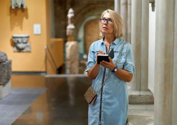 Frau mit Führer schaut sich Bilder im Kunstmuseum an — Stockfoto