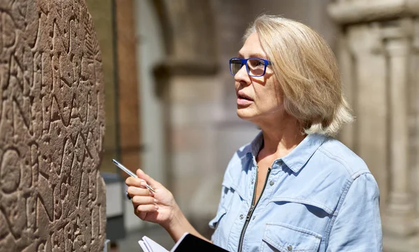 Mulher estudando hieróglifos de escrita antiga no museu . — Fotografia de Stock