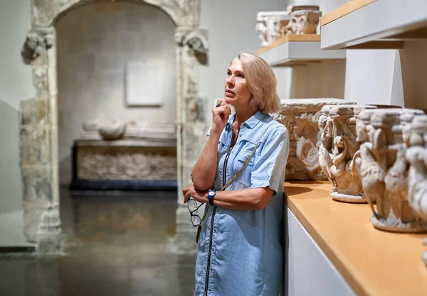 Femme mature visiteur dans le musée historique regardant objet d'art . — Photo