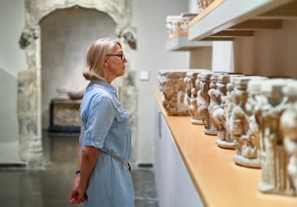 Mulher visitante em museu histórico olhando para objeto de arte . — Fotografia de Stock