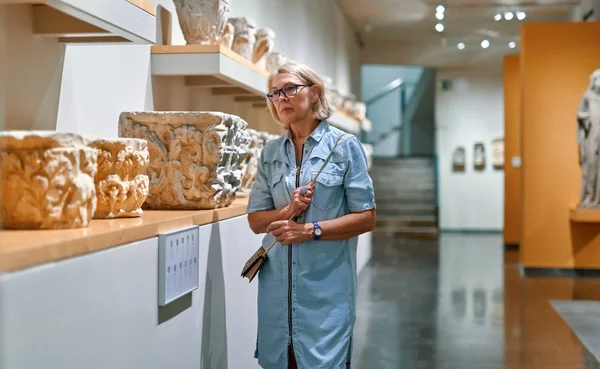Mulher visitante em museu histórico olhando para objeto de arte . — Fotografia de Stock