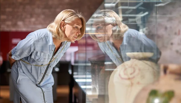 Vrouw zoekt oude amphores in Museum. — Stockfoto