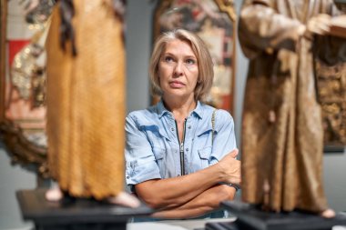 Sanat galerisi müzesinde sanat nesnesi görünümlü olgun kadın.