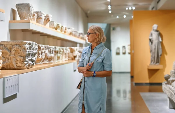 Femme adulte regardant une sculpture d'art dans le musée à l'intérieur. — Photo