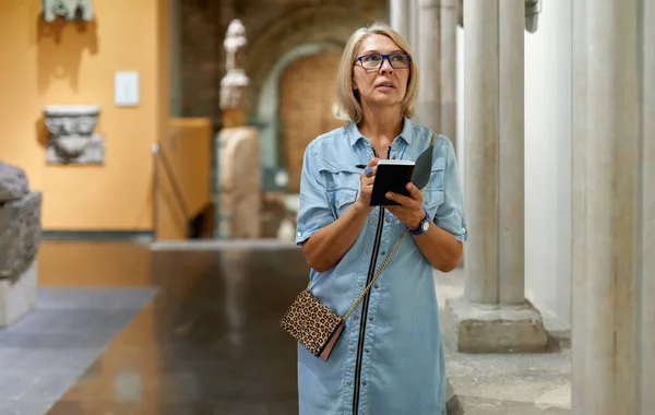 Vrouw met een gids kijken naar Foto's in Museum of Arts — Stockfoto