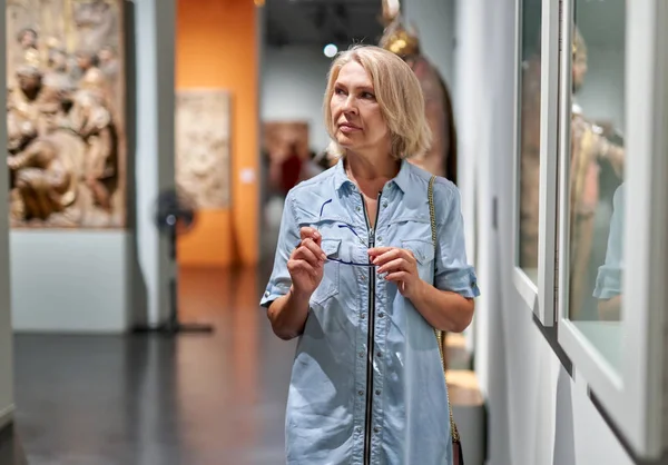 Vrouw bezoeker in het historisch museum kijken naar Exhibit. — Stockfoto