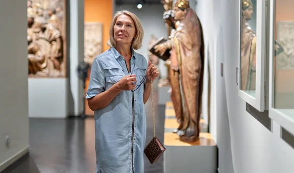 Visitante mulher olhando para exposição no museu de escultura antiga . — Fotografia de Stock