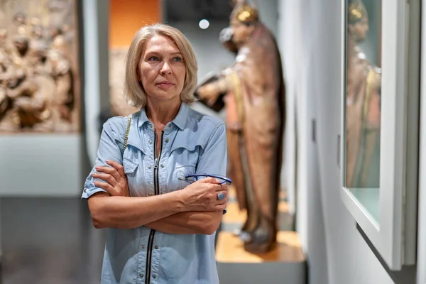 Femme mûre visiteur dans le musée historique regardant des photos — Photo