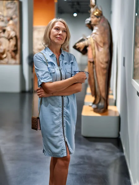 Dospělá žena v historickém muzeu, která se dívá na obrázky — Stock fotografie