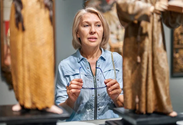 Femme mature visiteur regardant objet d'art dans la galerie d'art musée . — Photo