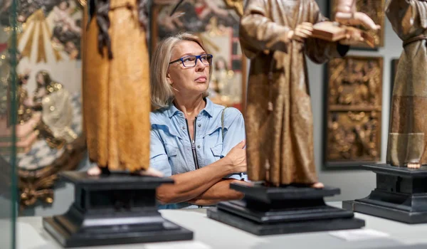 Woman visitor looking art object in art gallery museum.