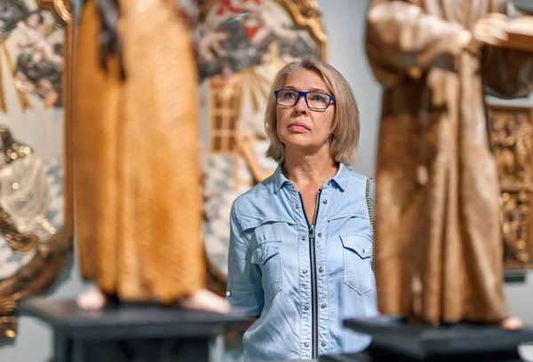 Woman visitor looking art object in art gallery museum.