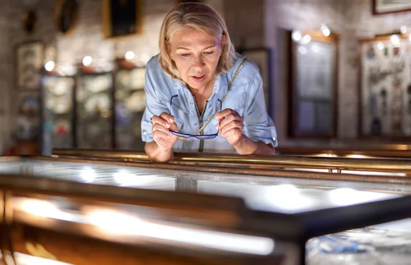 Vrouwelijke bezoeker in het historisch museum kijkt naar kunstobject. — Stockfoto