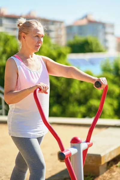Взрослая спортивная женщина делает упражнения на открытом воздухе . — стоковое фото
