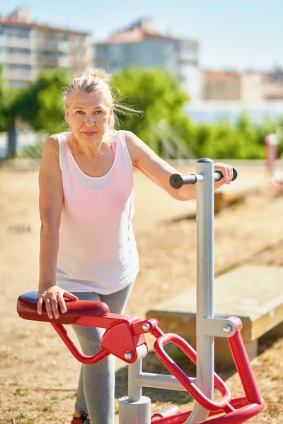 Доросла спортивна жінка робить вправи на відкритому повітрі . — стокове фото