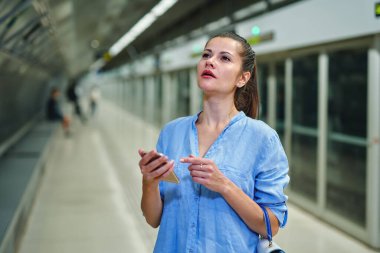 Metro istasyonunda el çantalı genç bir kadın..
