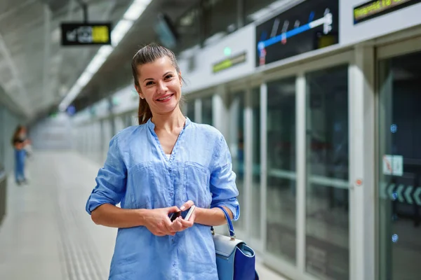 Jonge vrouw met handtas in metrostation. — Stockfoto