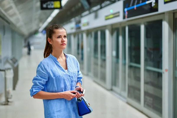 Jonge vrouw met handtas in metrostation. — Stockfoto