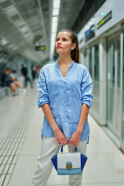 Jonge vrouw met handtas in metrostation. — Stockfoto