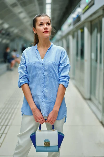 Jonge vrouw met een handtas in metrostation — Stockfoto