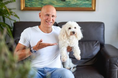 Evde sevimli köpeği olan yakışıklı bir adam.