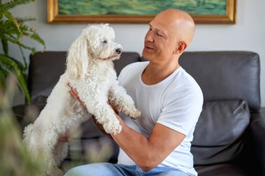 Evde sevimli köpeği olan yakışıklı bir adam.