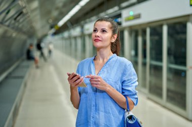Metro istasyonunda el çantalı genç bir kadın..