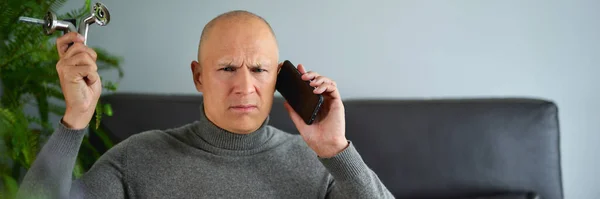 Hombre hablando en el teléfono móvil en el sofá —  Fotos de Stock