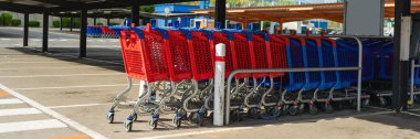 Market alışverişi için bir markette tramvay, bir mağazada alışveriş arabası, süpermarketin yakınındaki bir otoparkta bir sürü alışveriş arabası..