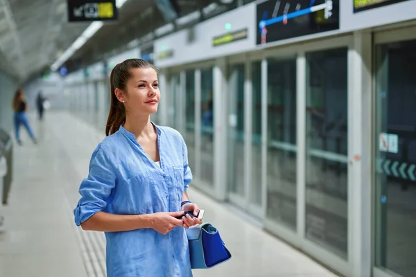 Jonge vrouw met handtas in metrostation. — Stockfoto