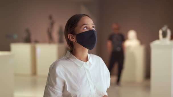 Vrouw bezoeker in masker virus protectionon in historisch museum kijken naar foto 's — Stockvideo